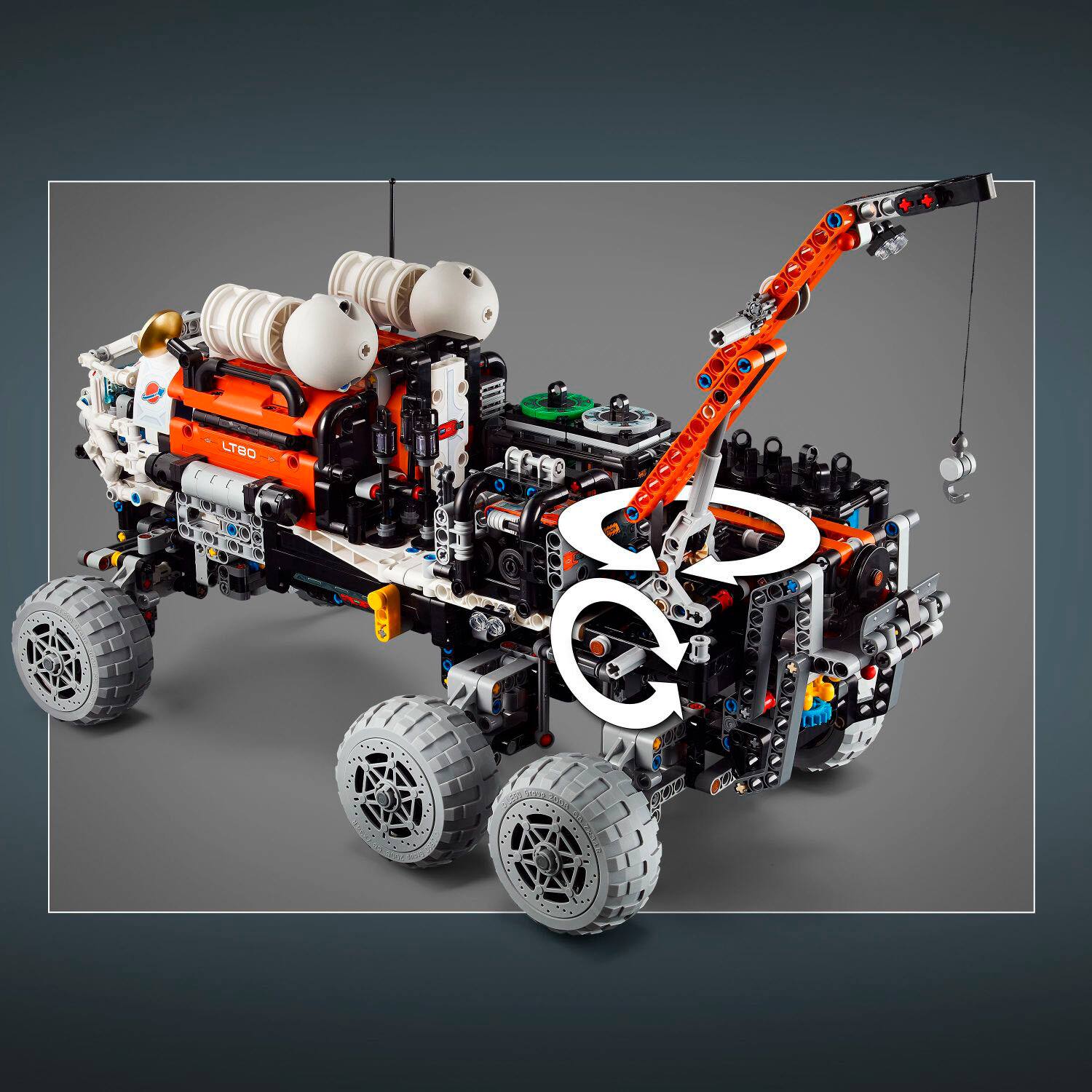The image features a large robot with a C on its side, which is likely a part of a Lego creation. The robot is made up of various parts, including a car, a wheel, and a tank. The Lego robot is designed to be a versatile vehicle, capable of performing different tasks and functions. The C on the side of the robot may represent a specific feature or purpose of the vehicle.