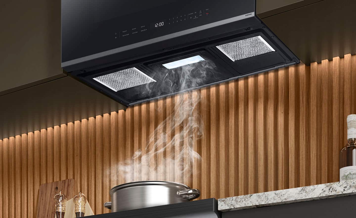 The image shows a kitchen with a stove top and a pot on it. The pot is filled with water and is placed on the stove, which is turned on. The stove has an exhaust fan above it, and steam is rising from the pot, indicating that the water is boiling. The kitchen also features a microwave and a countertop.