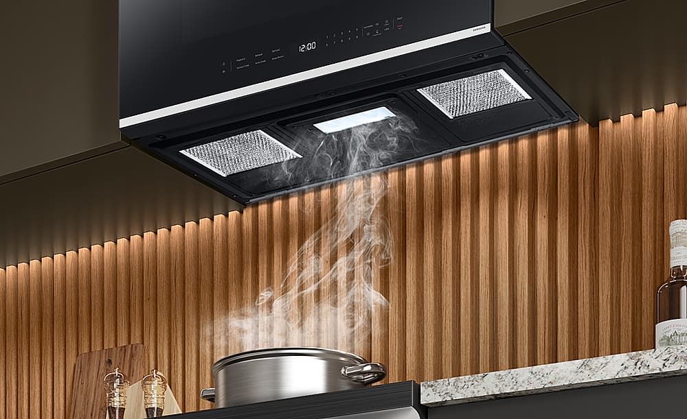 The text on the image reads "12:00 1 I 1 5 . & . - 2 CRAND OR EMILIO." However, this text does not seem to be related to the image of the kitchen. The image shows a stove with steam coming out of it, and the oven is open. The text does not provide any context or information about the scene.