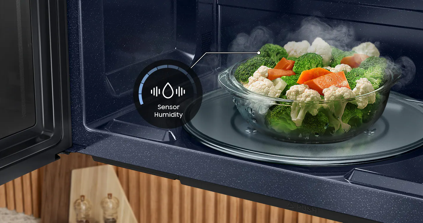 The image shows a microwave with a bowl of food inside it. The microwave has a sensor that measures humidity, and it is currently displaying a humidity reading of 40%. The bowl contains a variety of vegetables, including broccoli and carrots.