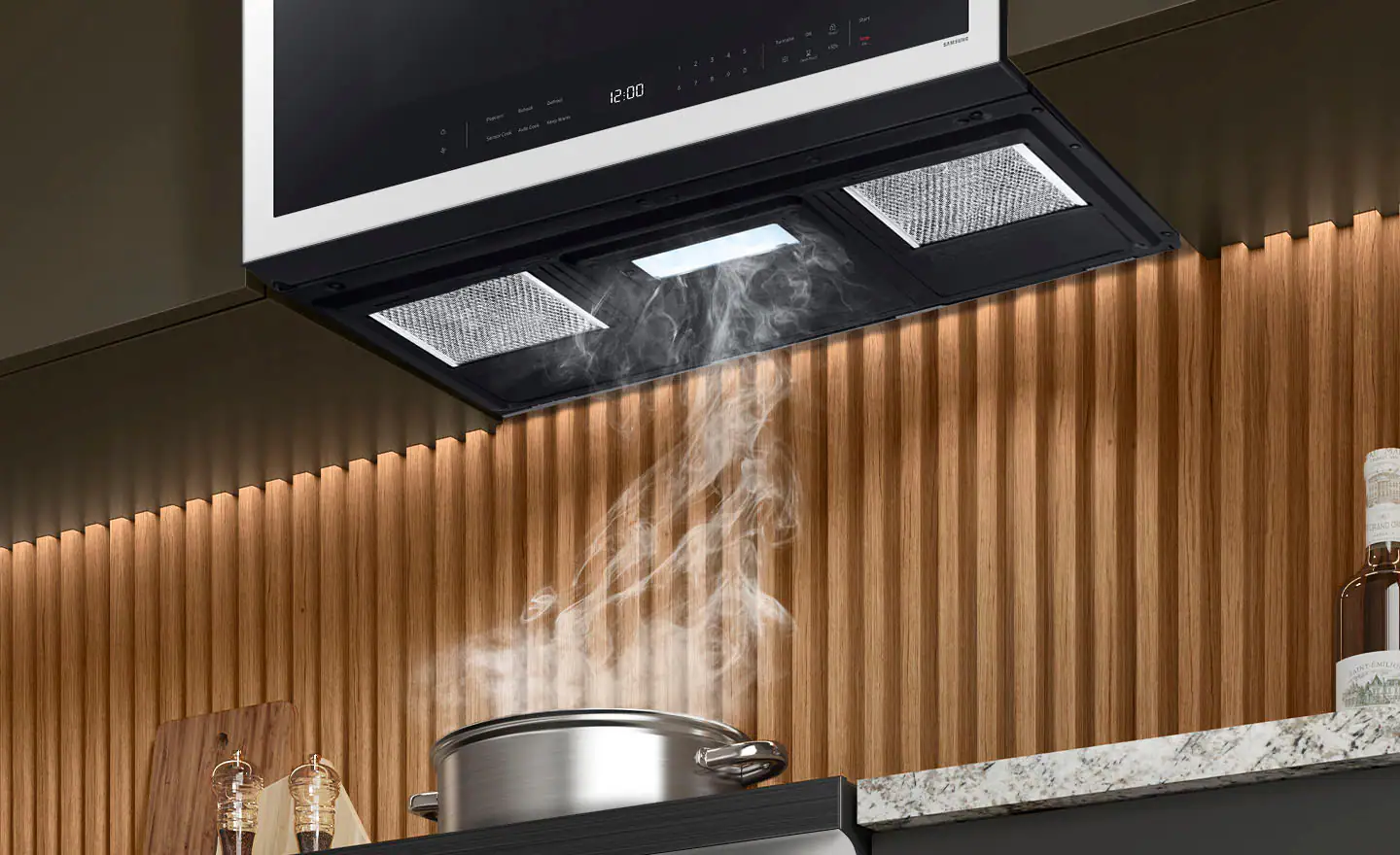 The image shows a kitchen with a stove top and a pot of food cooking on it. The pot is placed on the stove, and steam is rising from it. The kitchen also features a microwave and a ventilation system. The scene suggests that the food is being cooked with steam, which is a common method for cooking various dishes.