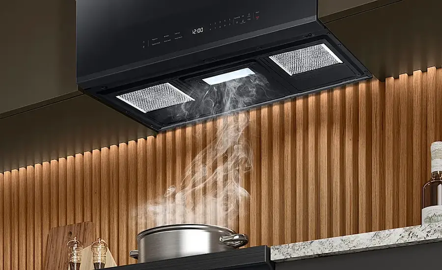 The image shows a kitchen scene with a pot on the stove. The stove is turned on, and the pot is filled with water. The steam from the boiling water is rising into the air, creating a visible effect. The image also features a microwave above the stove, and a bottle can be seen nearby.