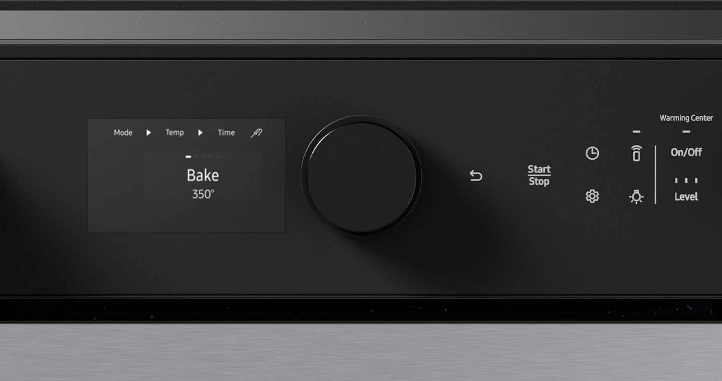 The image shows a black oven with a digital display. The display shows the mode, temperature, time, and warming center settings. The mode is set to "Bake," and the temperature is set to 350 degrees. The time and warming center settings are not visible in the image. The oven has a knob to control the settings, and the display is located on the front of the oven.