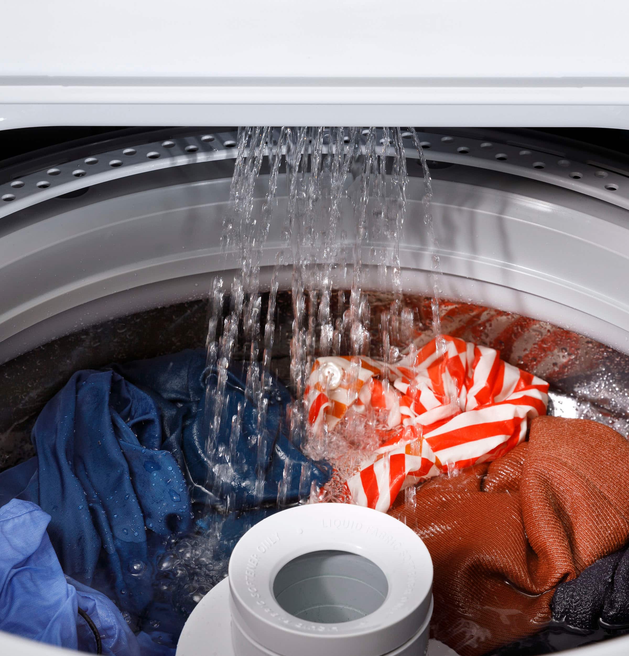 A washing machine is filled with clothes and water, and the clothes are being washed.