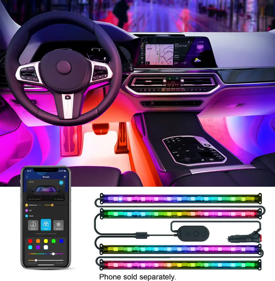The image showcases a car interior with a steering wheel and a cell phone. The car is equipped with a colorful light strip that illuminates the interior, creating a vibrant and lively atmosphere. The car's interior is also adorned with a colorful light strip, adding to the overall visual appeal. The cell phone is placed on the car's dashboard, possibly for navigation or entertainment purposes. The car's interior is well-lit, making it a comfortable and enjoyable space for driving and relaxing.