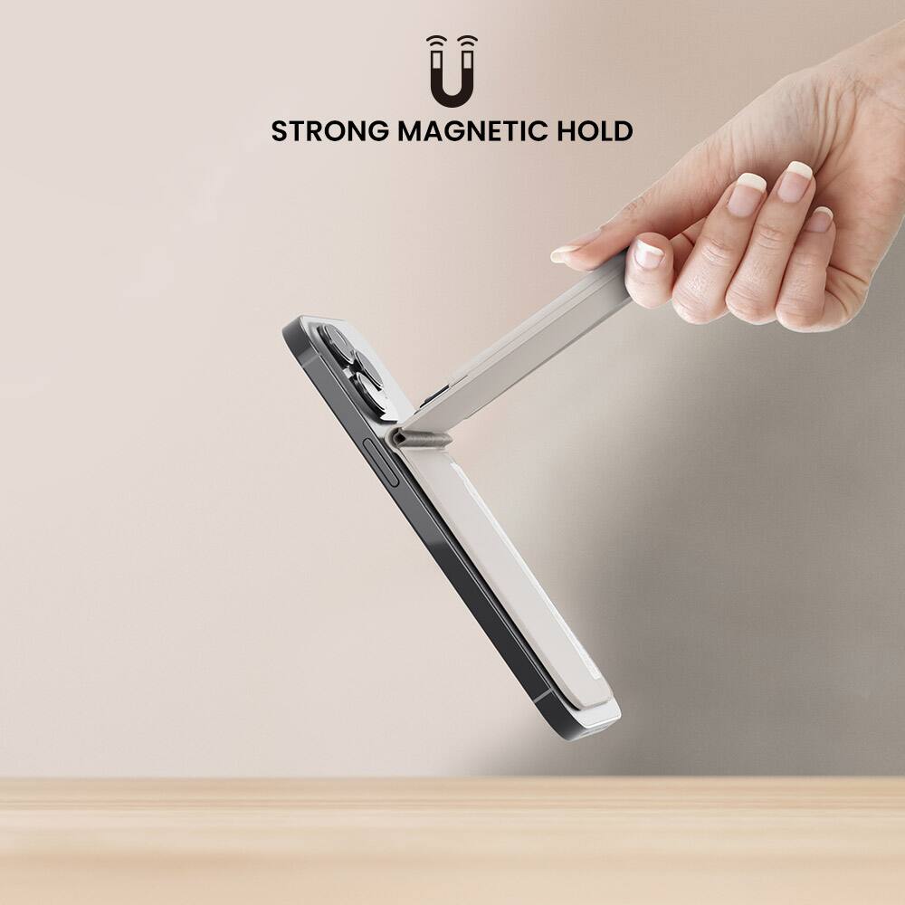 The image shows a person holding a wallet or clutch in their hand, with a strong magnetic hold keeping the wallet securely in place. The wallet is attached to a metal surface, such as a table, using the magnetic hold. The person's hand is positioned above the wallet, showcasing the strength of the magnetic hold.