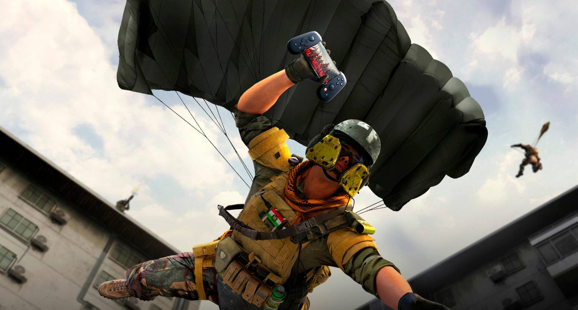 The image features a man in a tan uniform with a parachute on his back, holding a game controller. He is in the middle of a jump, possibly in a video game. The man is wearing a helmet and is holding the controller in his hand. The scene is set against a backdrop of a building, and the man appears to be the main focus of the image.