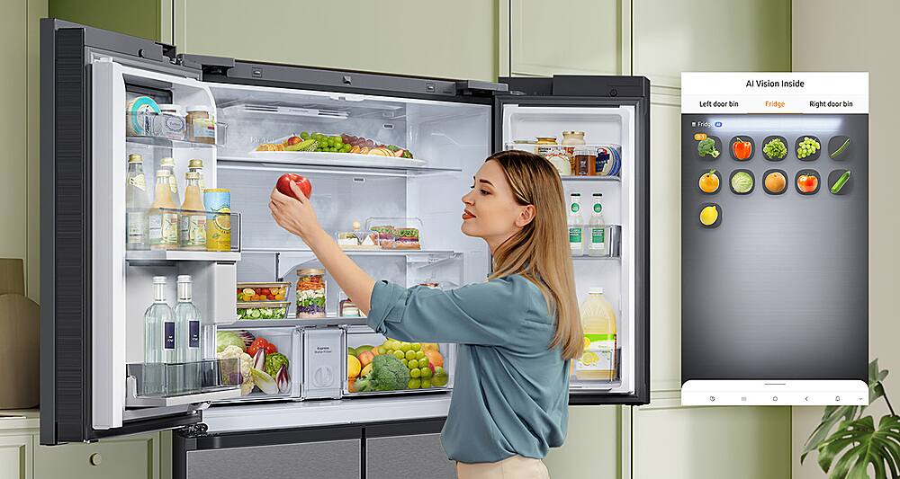 The image features a woman standing in front of a large refrigerator, which is part of a Full_Size_Refrigerators category. The refrigerator has a large door with a bin inside, and it is filled with various food items, including apples and oranges. The woman is reaching into the refrigerator, possibly looking for something to eat or drink. The scene showcases the convenience and functionality of the refrigerator, which is designed to store and organize food items efficiently.