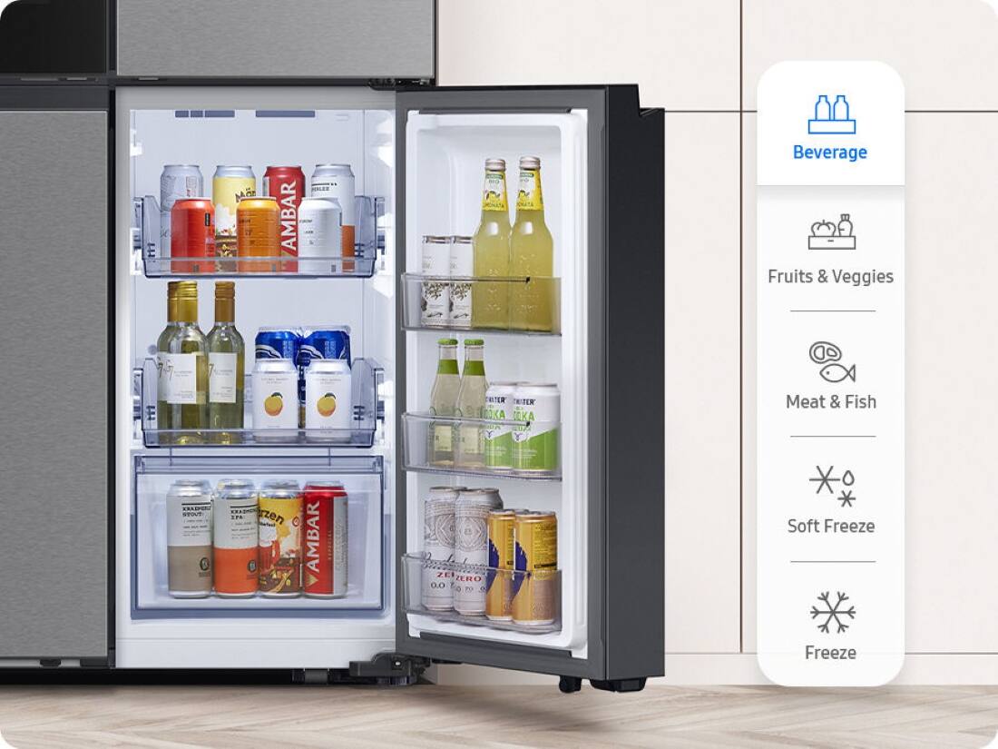 The image features a refrigerator with its door open, revealing a variety of drinks and food items inside. There are several bottles of beverages, including a bottle of wine, and a few bottles of juice. The refrigerator also contains a few fruits, such as apples and oranges. The refrigerator is equipped with a freezer, which is located on the bottom right side. The refrigerator is placed in a kitchen setting, with a tile floor visible in the background.
