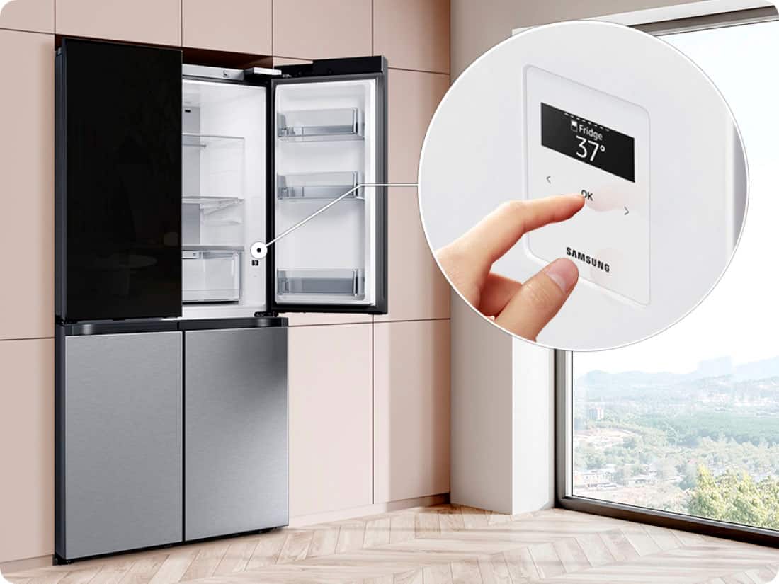 The image features a Samsung refrigerator with a large text that reads "Fridge 37 OK." The refrigerator is placed in a kitchen, and there is a window nearby. The refrigerator is empty, and a hand is seen interacting with the digital display, possibly adjusting the temperature or settings. The scene showcases a modern kitchen with a focus on the Samsung appliance.