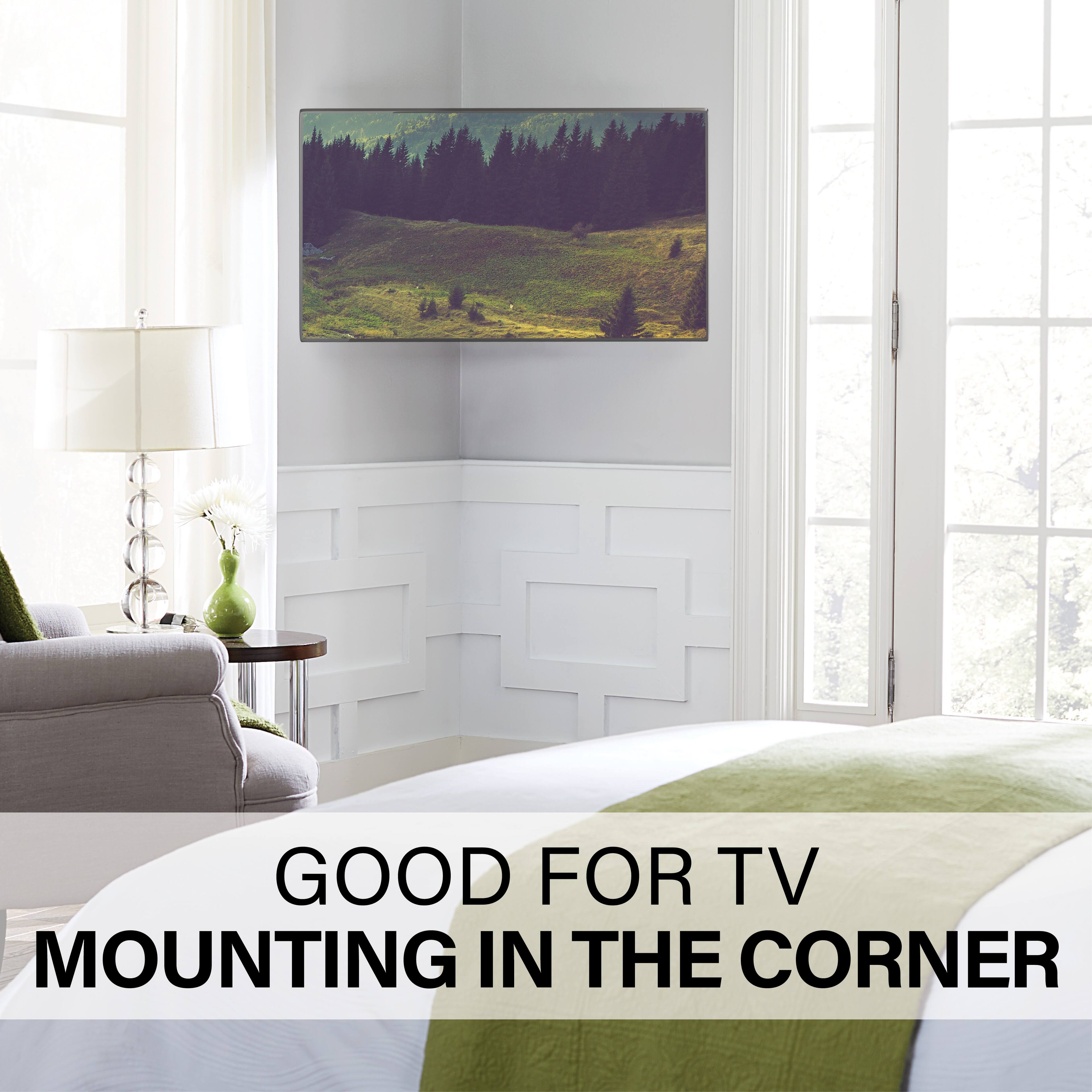 The image shows a bedroom with a large flat-screen TV mounted on the wall near the corner of the room. The TV is positioned above a bed, and there is a chair nearby. The room also features a window, providing natural light to the space. The overall setting suggests that the TV mounting in the corner is a good choice for this room, as it maximizes the use of available space and creates a comfortable viewing experience.