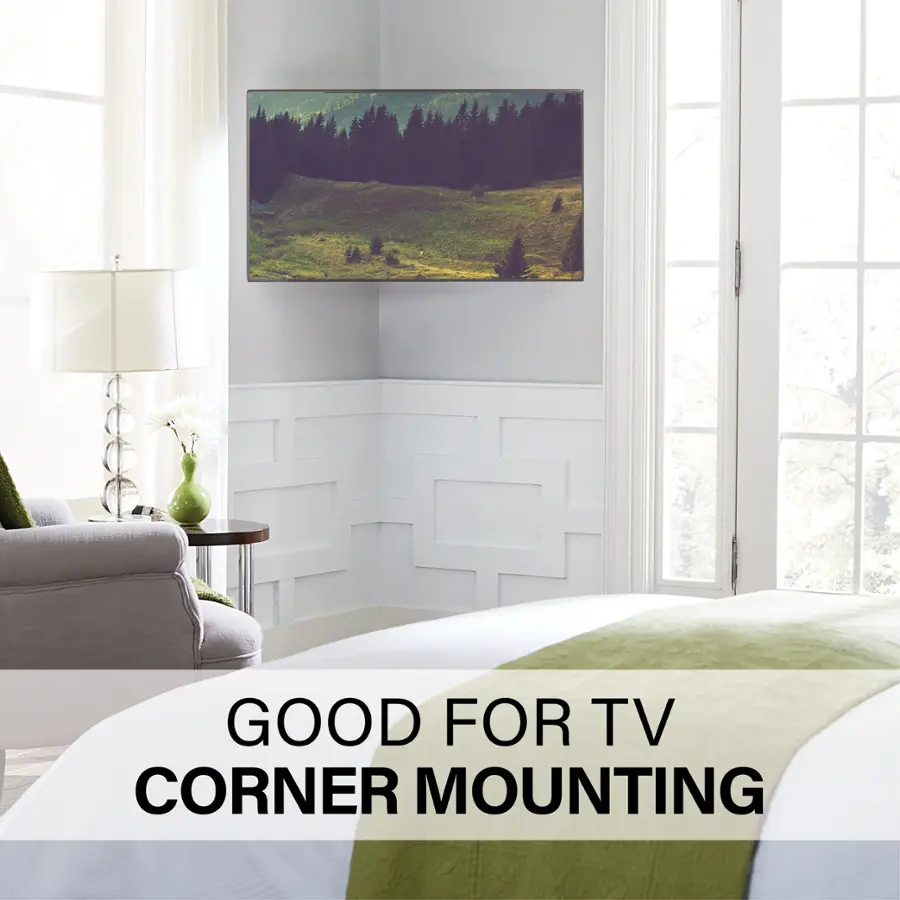 The image features a cozy bedroom with a large flat-screen TV mounted on the wall above a bed. The TV is placed in a corner, making it an ideal spot for watching TV while relaxing in bed. The room also includes a couch and a chair, providing additional seating options for watching TV or enjoying other leisure activities. The presence of a window in the room allows for natural light to enter, creating a bright and inviting atmosphere.