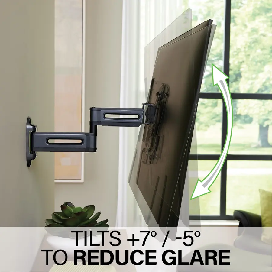 The image shows a large flat screen TV mounted on a wall, with a potted plant placed nearby. The TV is tilted at an angle to reduce glare, which is a common issue with flat screen TVs. The tilt adjustment helps to minimize reflections and improve the viewing experience by directing the light from the screen towards the viewer. The TV is positioned in front of a window, which can also contribute to glare, so the tilt adjustment is particularly useful in this setting.