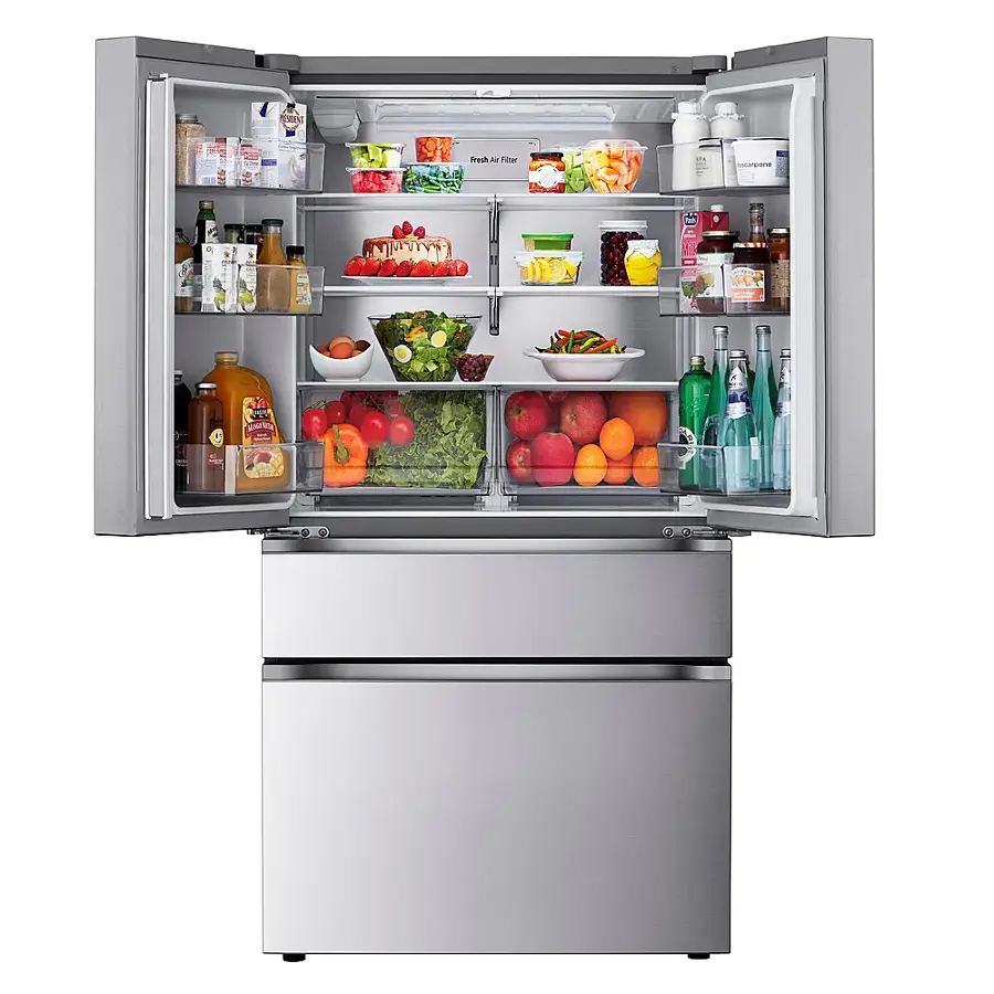 The image shows a large refrigerator with its door open, revealing a variety of food items inside. The refrigerator is filled with fresh produce, including several bottles of juice, oranges, and apples. There are also a few bowls containing different food items, such as broccoli and carrots. The refrigerator is well-stocked, with a wide assortment of items to choose from.