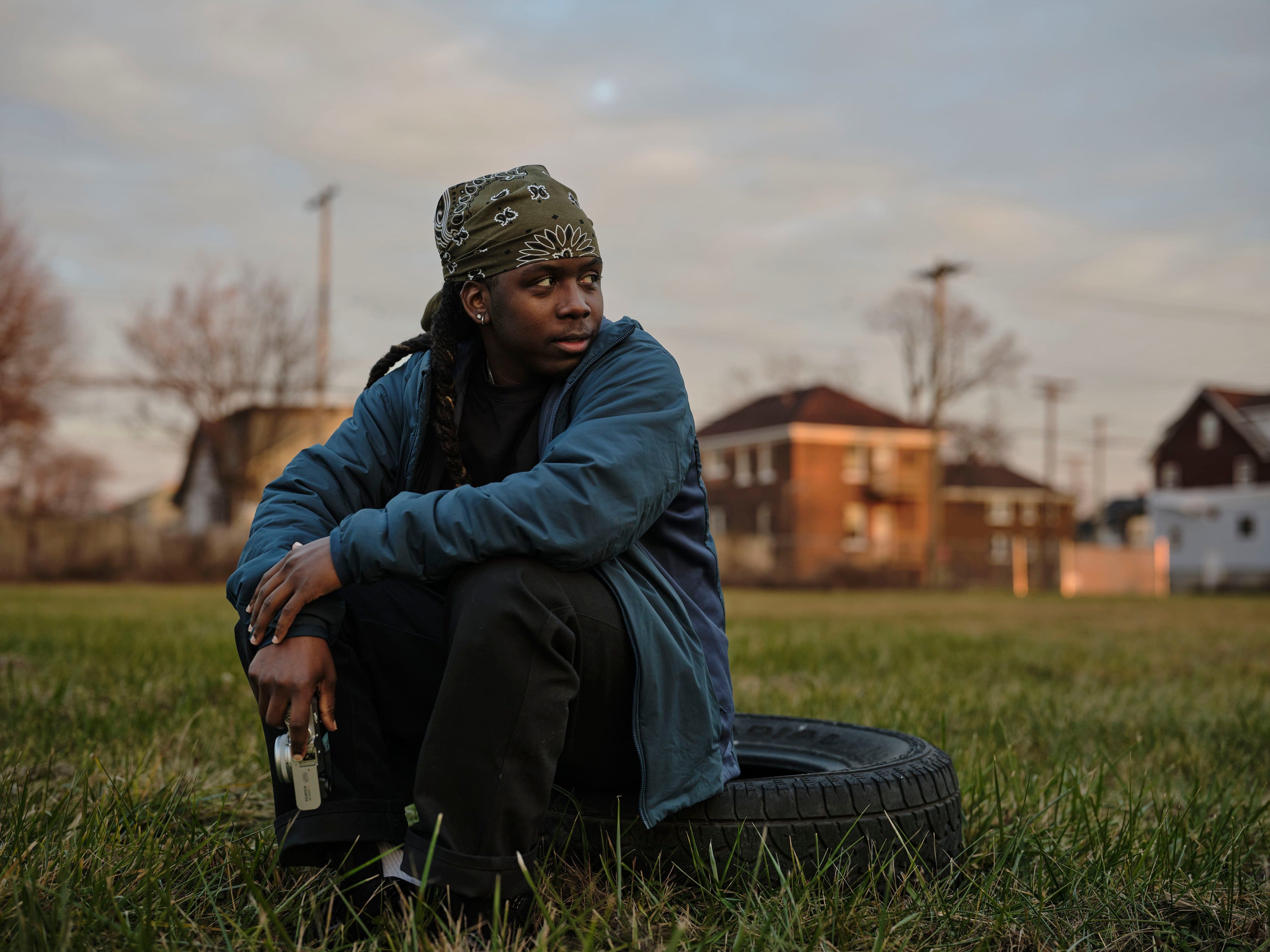 The man is sitting in the grass.