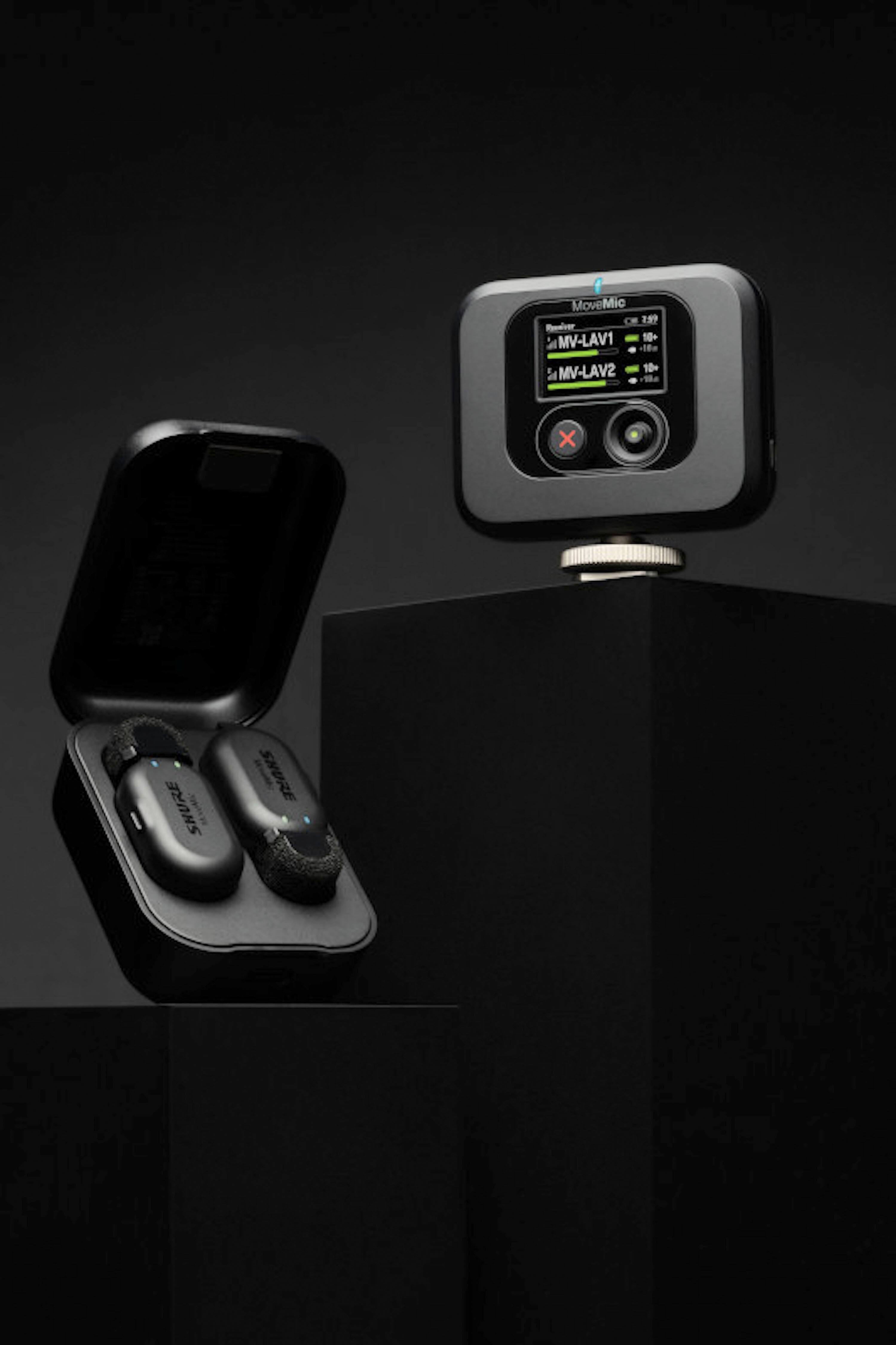The image features a cell phone with a Mission Control app on the screen, which allows for direct-to-phone recording. The phone is placed on a table, and there are two earphones nearby. The ShurePlus MOTIV app enables users to access various features, such as speech mode, mute, and presets, to enhance their recording experience.