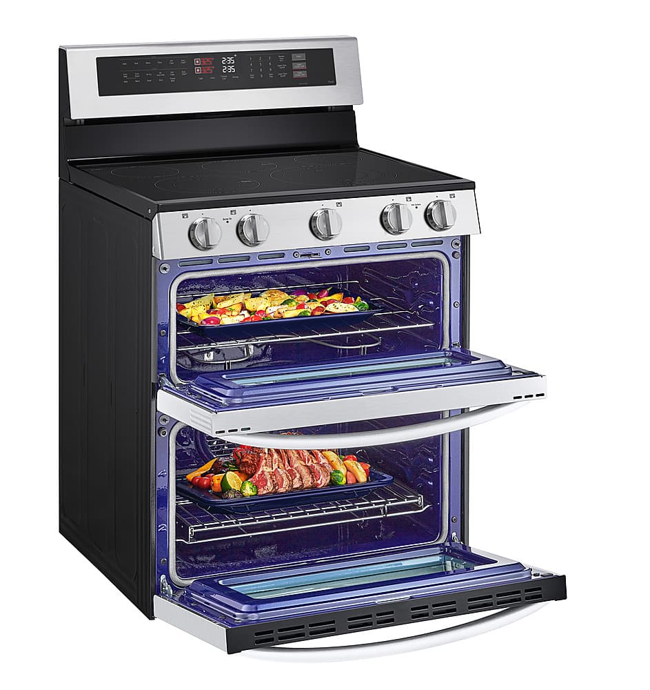 The image features a black and silver oven with two racks inside. The oven is filled with various food items, including broccoli and carrots. The oven has a digital display and a timer, which is set at 235 degrees. The oven is open, revealing the food items inside.