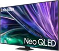 The image features a large Samsung Neo QLED television screen with a purple background. The television is prominently displayed, taking up most of the image. The Samsung logo is visible on the screen, emphasizing the brand and model of the TV. The Neo QLED technology is known for its high-quality display and advanced features, making it a popular choice for entertainment and gaming enthusiasts.