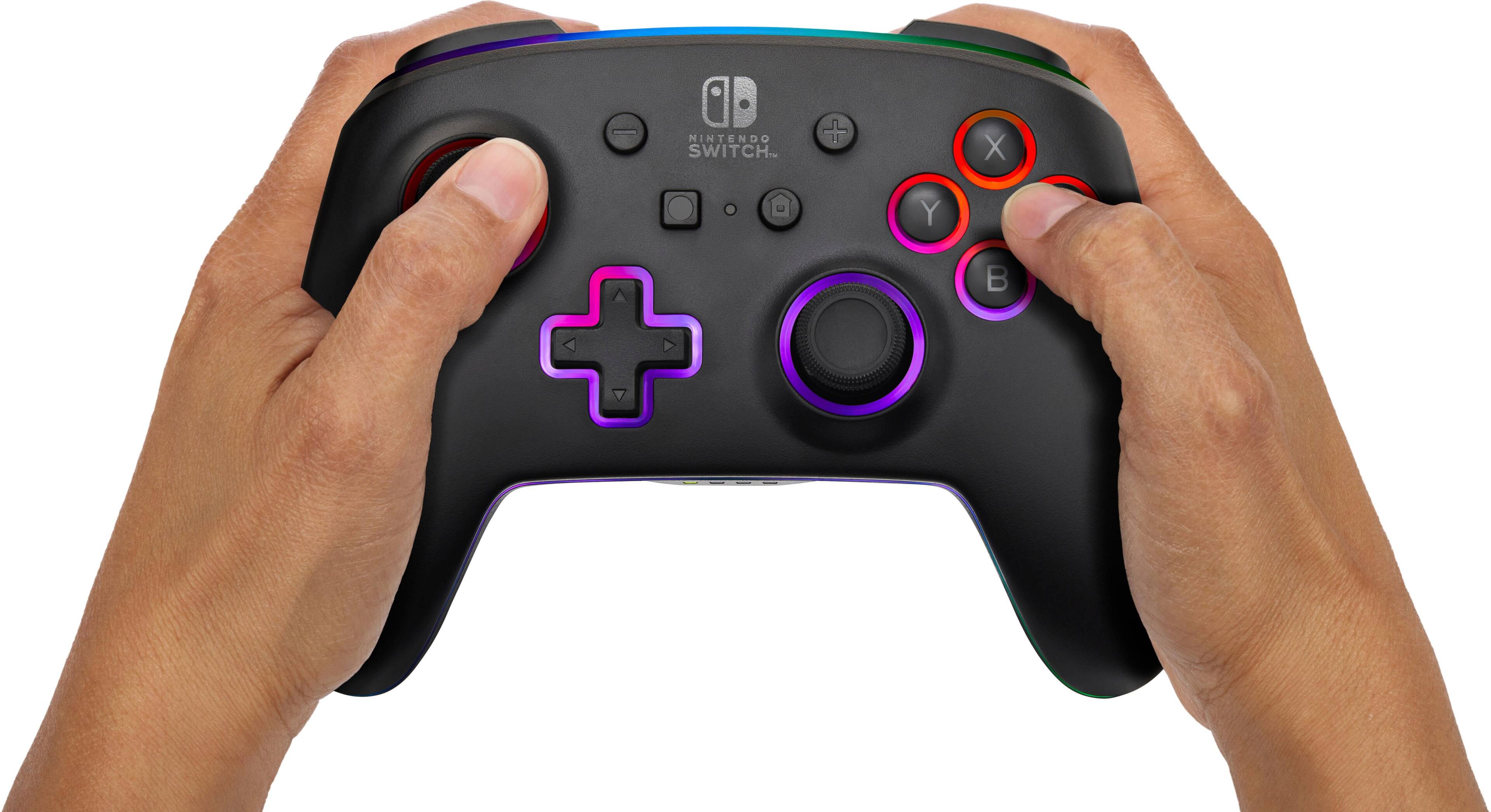 The image shows a person holding a Nintendo Switch game controller with their fingers on the buttons. The controller has a purple button and a red button, along with the standard A, B, X, and Y buttons. The person is likely playing a video game on the Nintendo Switch console.