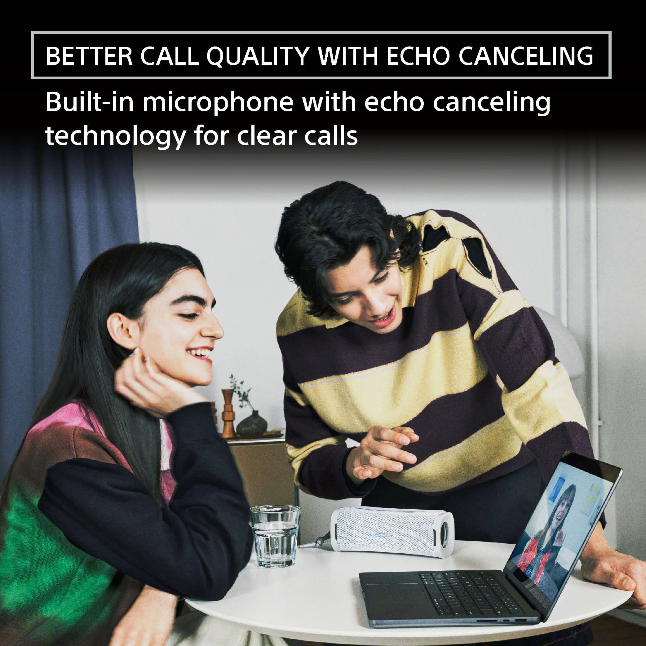 The image features a man and a woman sitting at a table, engaged in a conversation. The man is holding a laptop, while the woman is smiling and leaning on her hand. The scene suggests that they are having a pleasant discussion, possibly related to the content displayed on the laptop. The image also highlights the importance of clear communication, as the man and woman are using a built-in microphone with echo canceling technology for better call quality. This technology helps to minimize background noise and echoes during calls, resulting in more effective and enjoyable conversations.