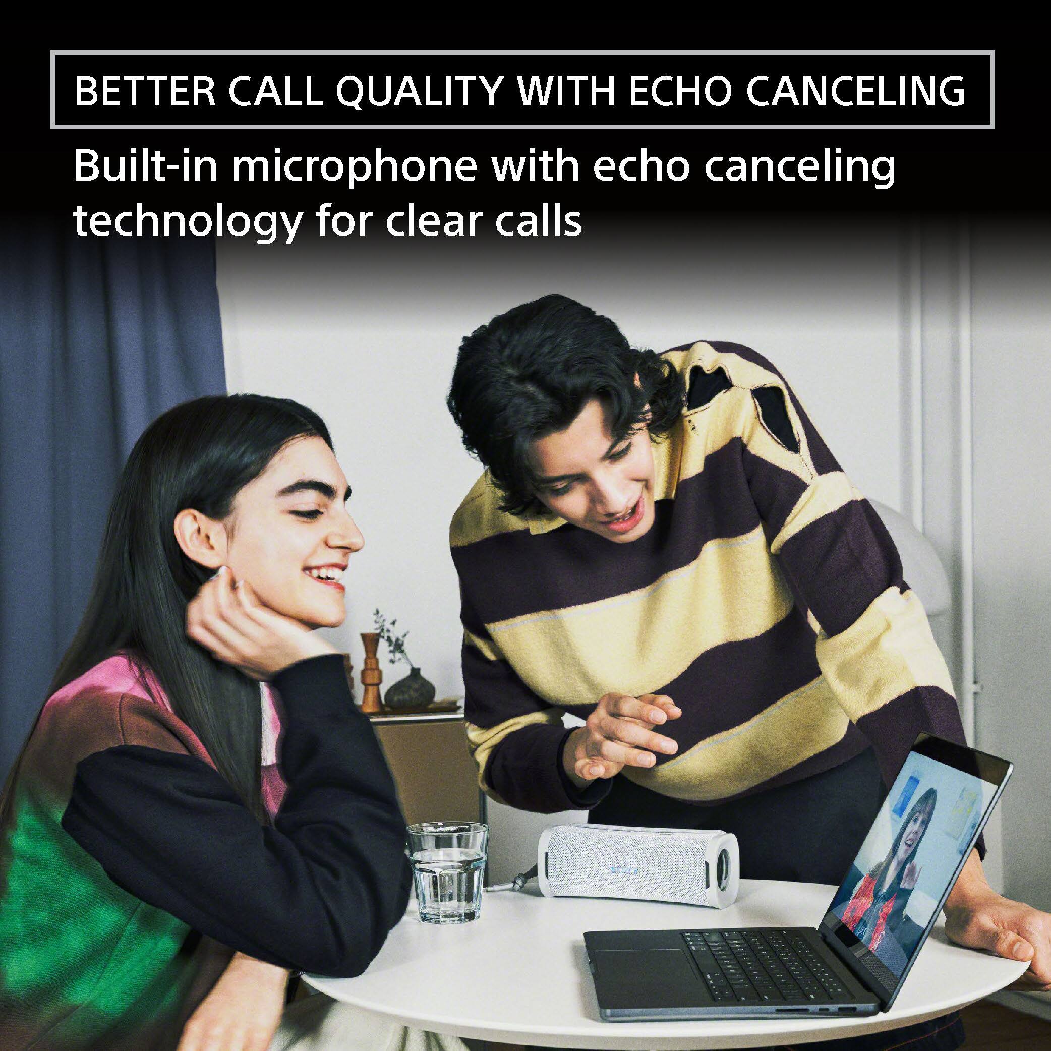 The image features a man and a woman sitting at a table, engaged in a conversation. The man is holding a laptop, while the woman is smiling and leaning on her hand. The scene suggests that they are having a pleasant discussion, possibly related to the content displayed on the laptop. The image also highlights the importance of clear communication, as the man and woman are using a built-in microphone with echo canceling technology for better call quality. This technology helps to minimize background noise and echoes during calls, resulting in more effective and enjoyable conversations.