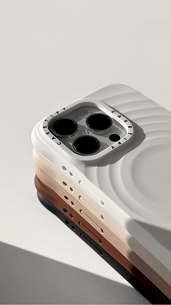 The image features a white and brown cell phone case with a black center. The case is designed to protect the phone from scratches and minor impacts. The case has a unique design with a black center, which adds a touch of style to the device. The case is placed on a white surface, which provides a clean and minimalist background for the image.