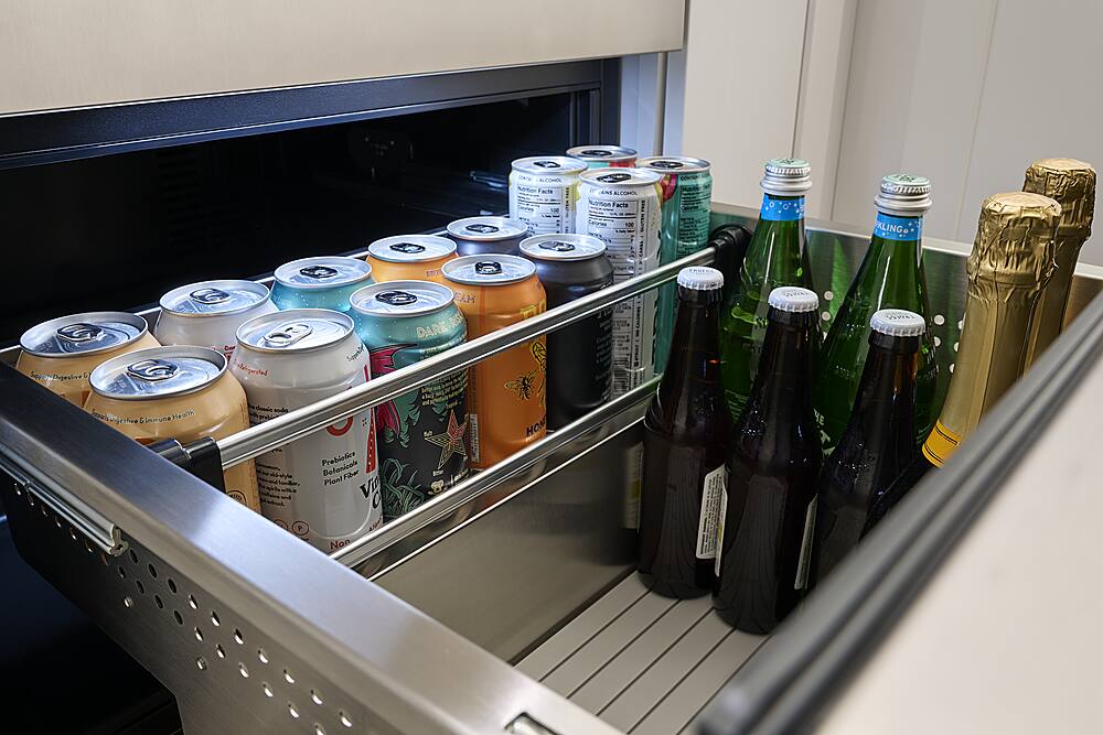 The image shows a refrigerator with a variety of drinks, including alcoholic beverages such as beer and wine. The refrigerator is filled with different types of drinks, including bottles and cans. Some of the drinks are placed on a shelf, while others are stored in the refrigerator. The variety of drinks suggests that the refrigerator is well-stocked to cater to the diverse preferences of its users.