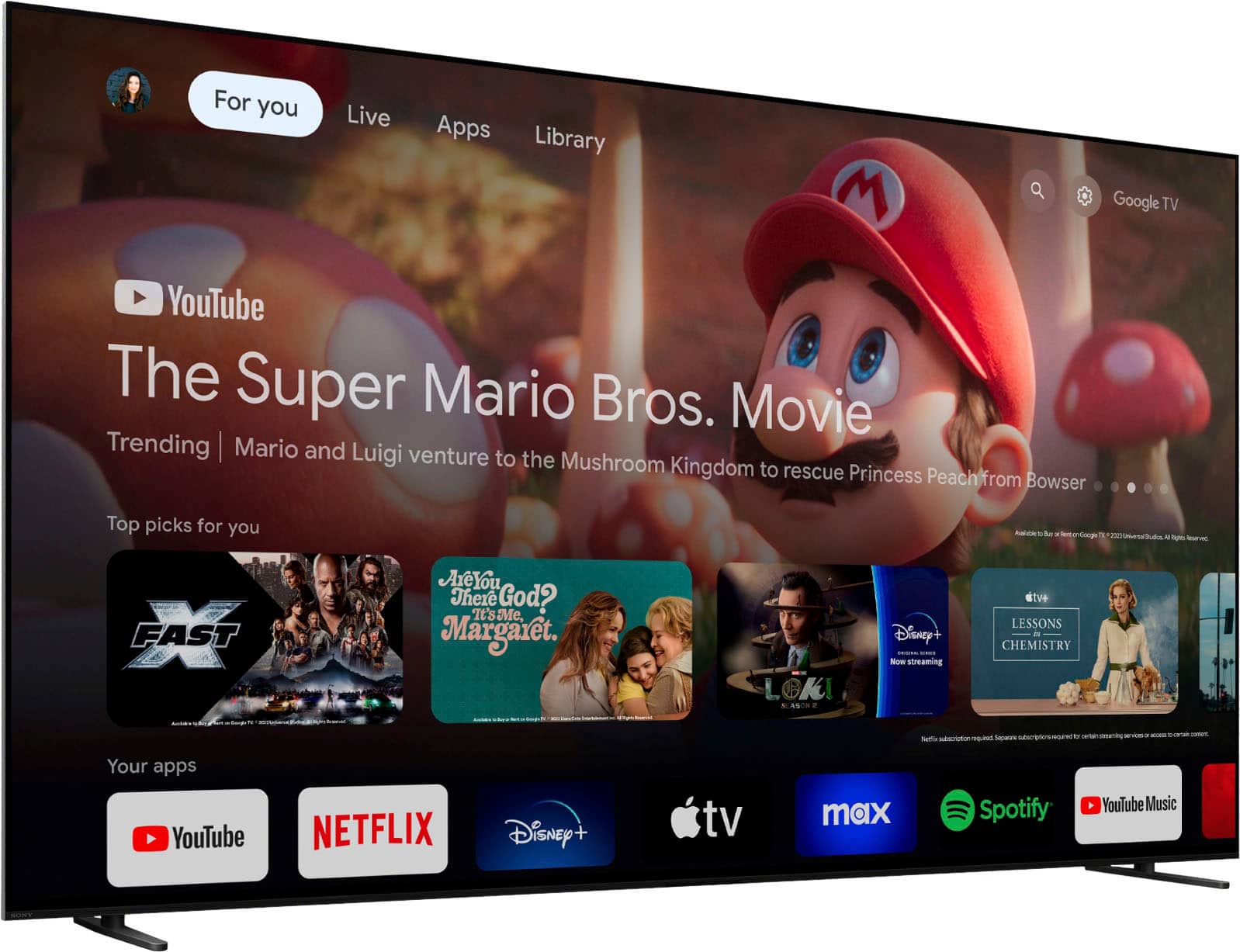 The image features a large flat screen TV displaying various apps and content, including YouTube, Netflix, Disney+, and Spotify. The TV is also showing a movie, specifically "The Super Mario Bros. Movie." The TV screen is filled with different content, making it a one-stop entertainment hub for users.