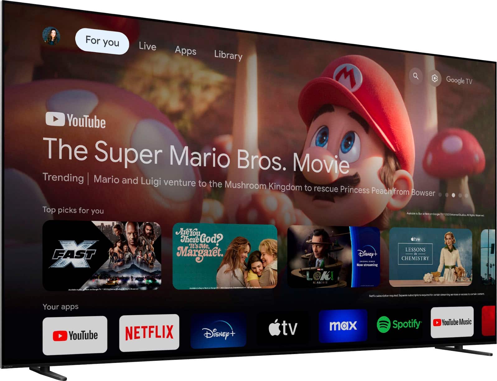 The image features a large flat screen TV displaying various apps and content, including YouTube, Netflix, Disney+, and Spotify. The TV is also showing a movie, specifically "The Super Mario Bros. Movie." The TV screen is filled with different content, making it a one-stop entertainment hub for users.