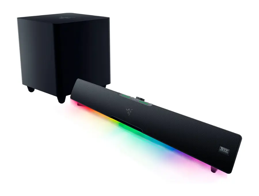 The image features a black speaker with a rainbow light on it, sitting next to a larger black speaker. The rainbow light is shining brightly, creating a visually appealing contrast with the black speakers. The speakers are placed on a white background, which further emphasizes the vibrant colors of the rainbow light.