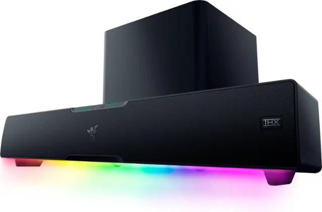 The image features a large black box, which is a THX-certified speaker system. The speaker system is placed on a white background, and the box is illuminated by a rainbow of light, giving it a visually appealing appearance. The THX logo is prominently displayed on the box, indicating its high-quality audio capabilities.