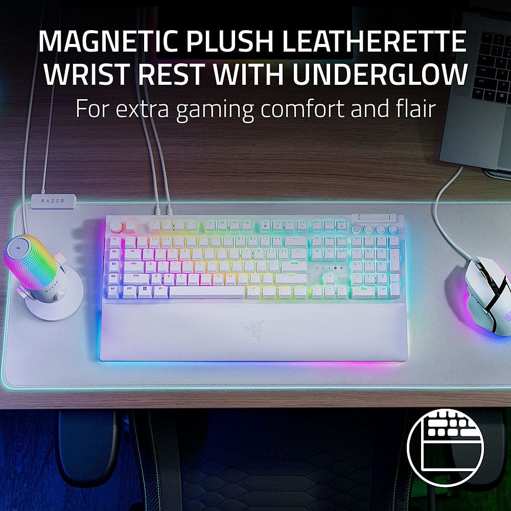 The image features a keyboard with a magnetic leatherette wrist rest and an underglow. The keyboard is designed by Razer and is likely intended for gaming purposes. The wrist rest is designed to provide extra comfort and flair to the user. The keyboard is placed on a desk, and there is a mouse nearby.