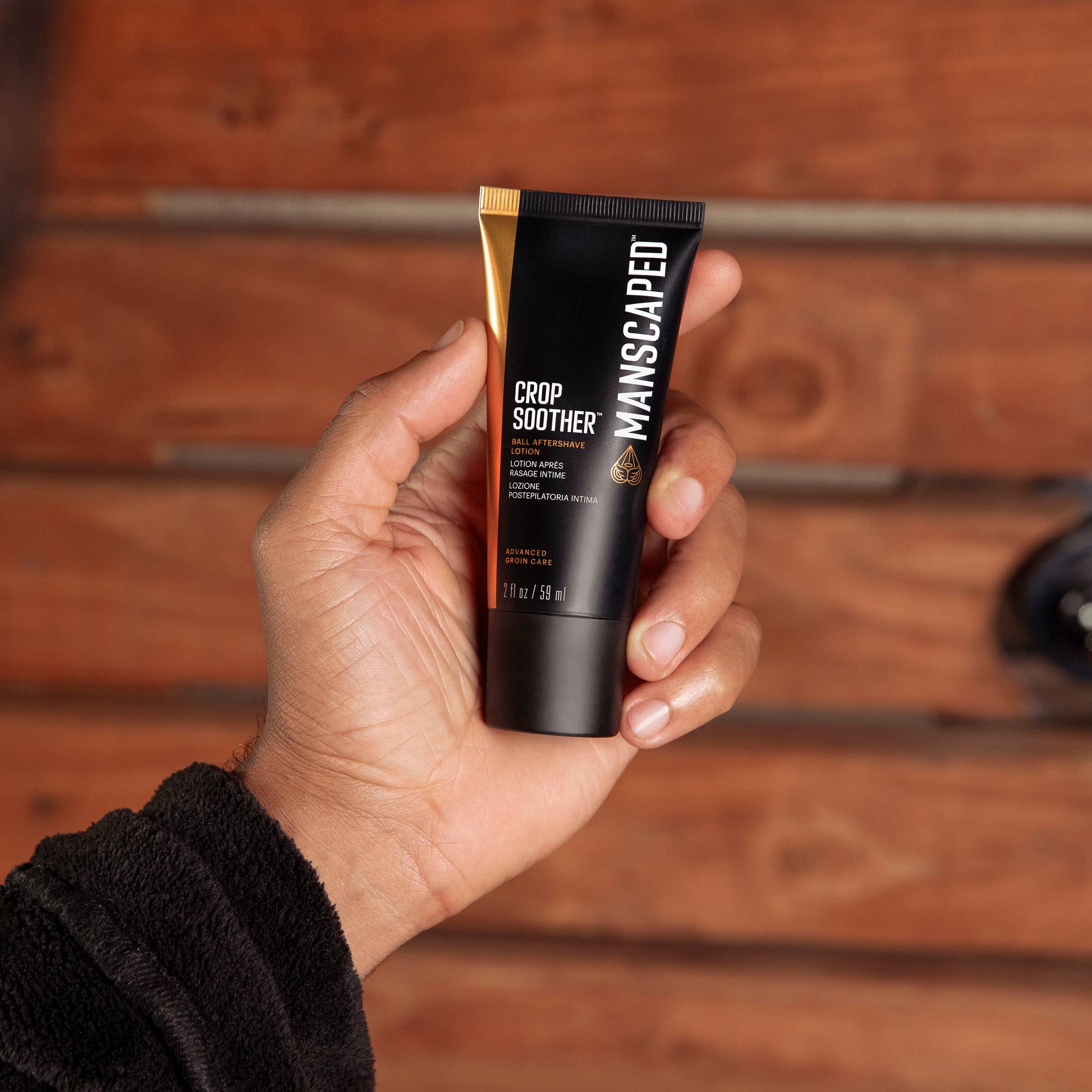 The text on the image reads: "SOOTHER dAA CROP AFTERSHAVE MANSCAPED cotaum LOTU APRES A NME LOCIONE POSTEPILATORIA t A BEVANGEO a aeoUm 2 CARE 1 i 12 I 59 ml."