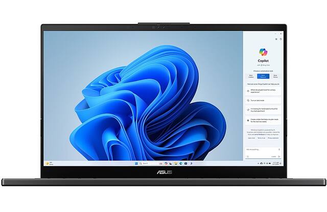 The image features a laptop computer with a blue background and a blue flower on the screen. The laptop is open, and the screen displays a blue and white image. The laptop is placed on a white background, which highlights the blue color of the flower and the blue background. The image is categorized as Laptop_Computers, and it showcases the laptop's design and features.