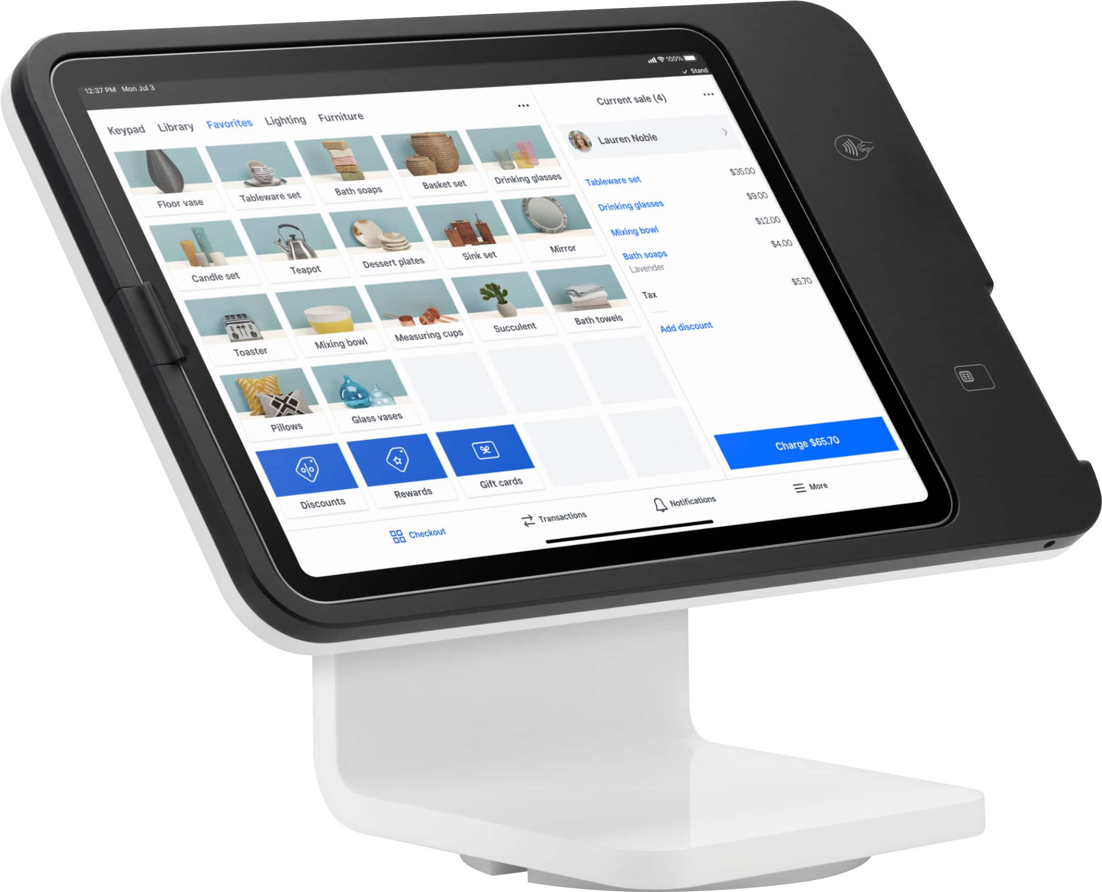 The image displays a tablet computer sitting on a stand. The tablet is turned on and shows a screen with several photos displayed. The photos are arranged in a grid-like pattern, with each photo occupying a square on the screen. The tablet is positioned at a slight angle, making it easy to view the photos.