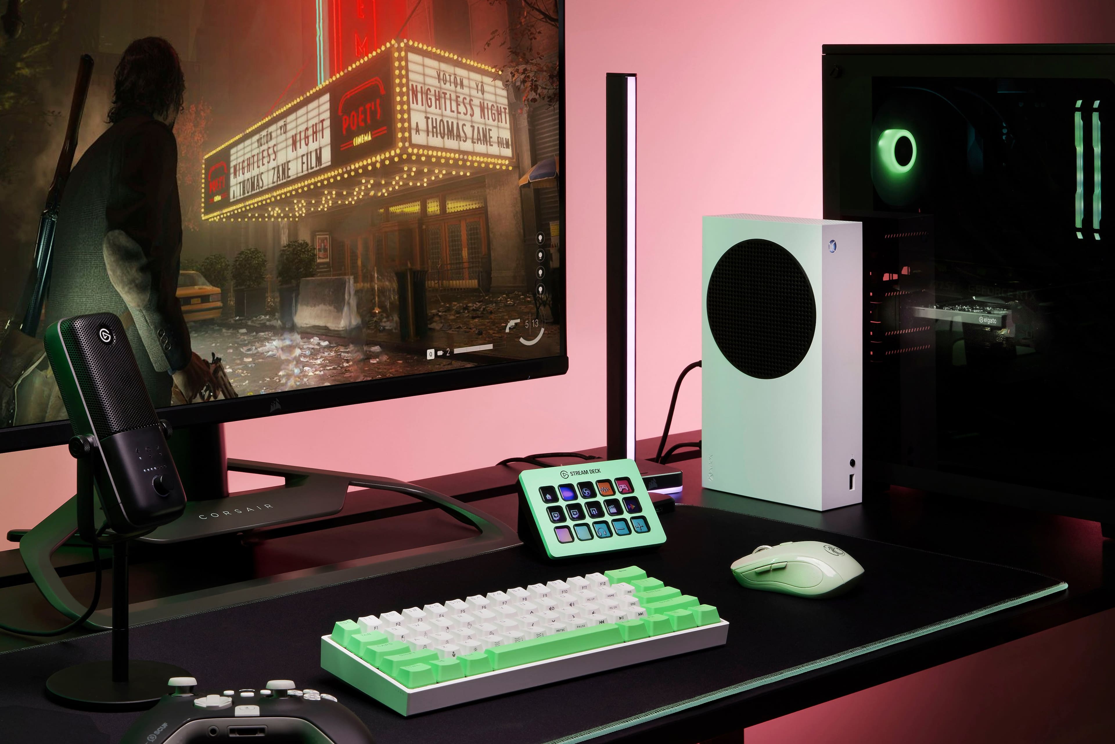 The image features a computer setup with a keyboard, mouse, and monitor. The monitor is displaying a video game, and there is a neon sign in the background. The keyboard is green and white, and the mouse is white. The scene appears to be set in a dimly lit room, with the computer setup being the main focus of the image.