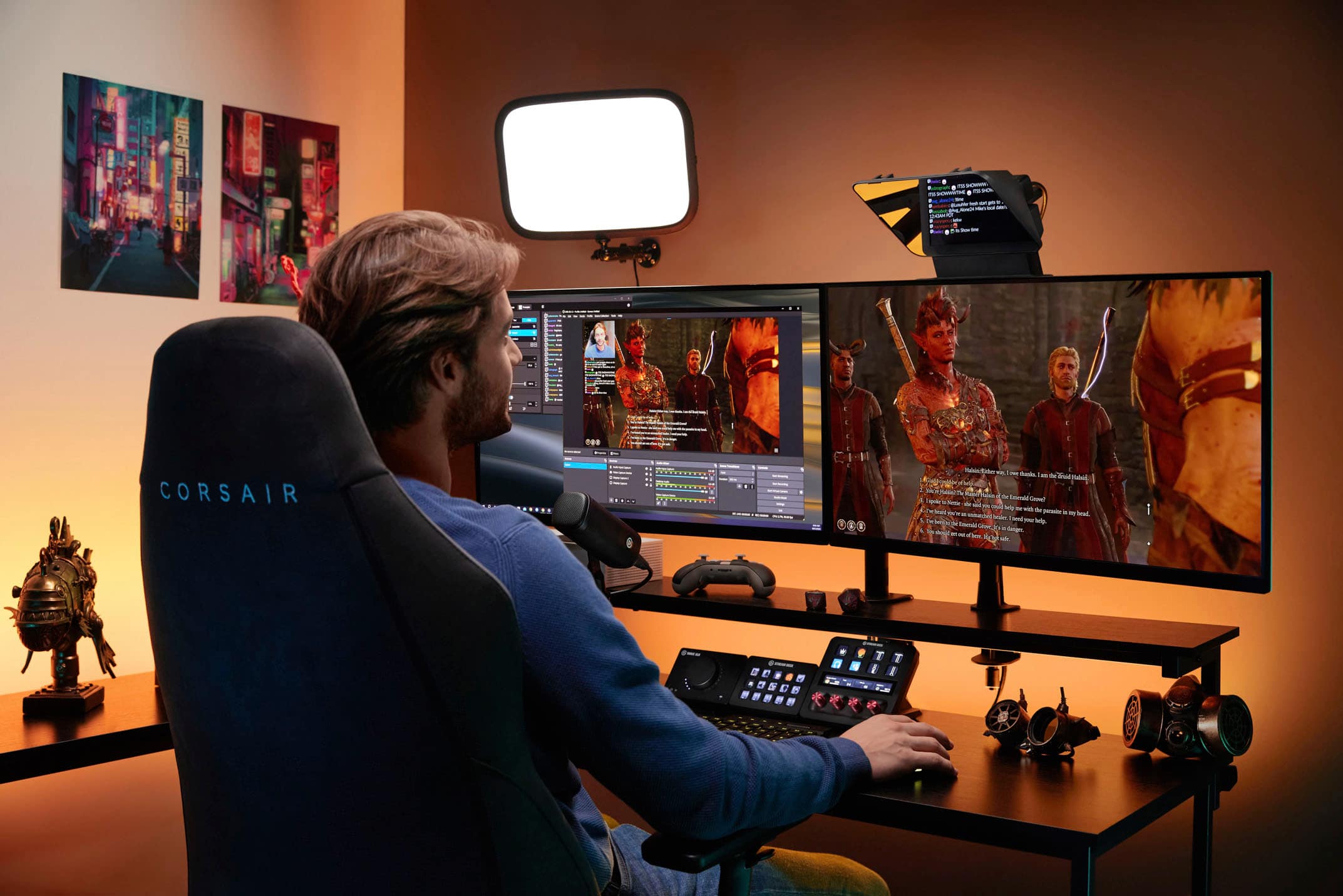 The image features a man sitting in a chair in front of a computer desk with three monitors. He is using a keyboard and a mouse to interact with the screens. The man is wearing a blue shirt, and there is a TV in the background. The scene is likely a workspace or a gaming setup, given the presence of multiple monitors.