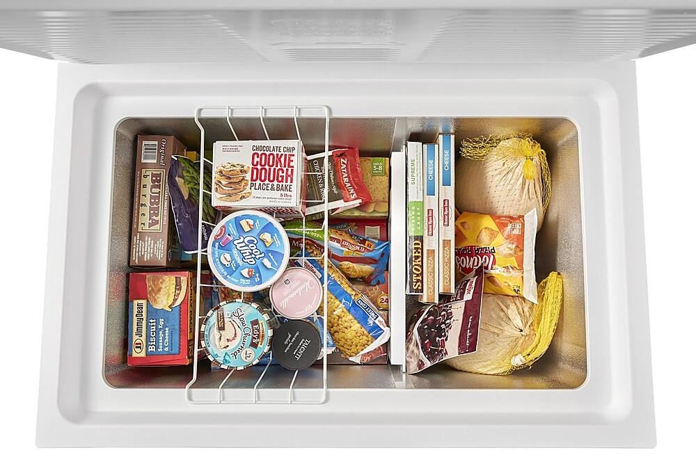 The image shows a refrigerator filled with various food items, including a cooler containing a pizza, a box of cookies, and a container of ice cream. There are also several books placed in the refrigerator, possibly for entertainment or reference while enjoying the food. The refrigerator is well-stocked with a variety of items, making it a convenient and enjoyable space for storing and accessing food and beverages.
