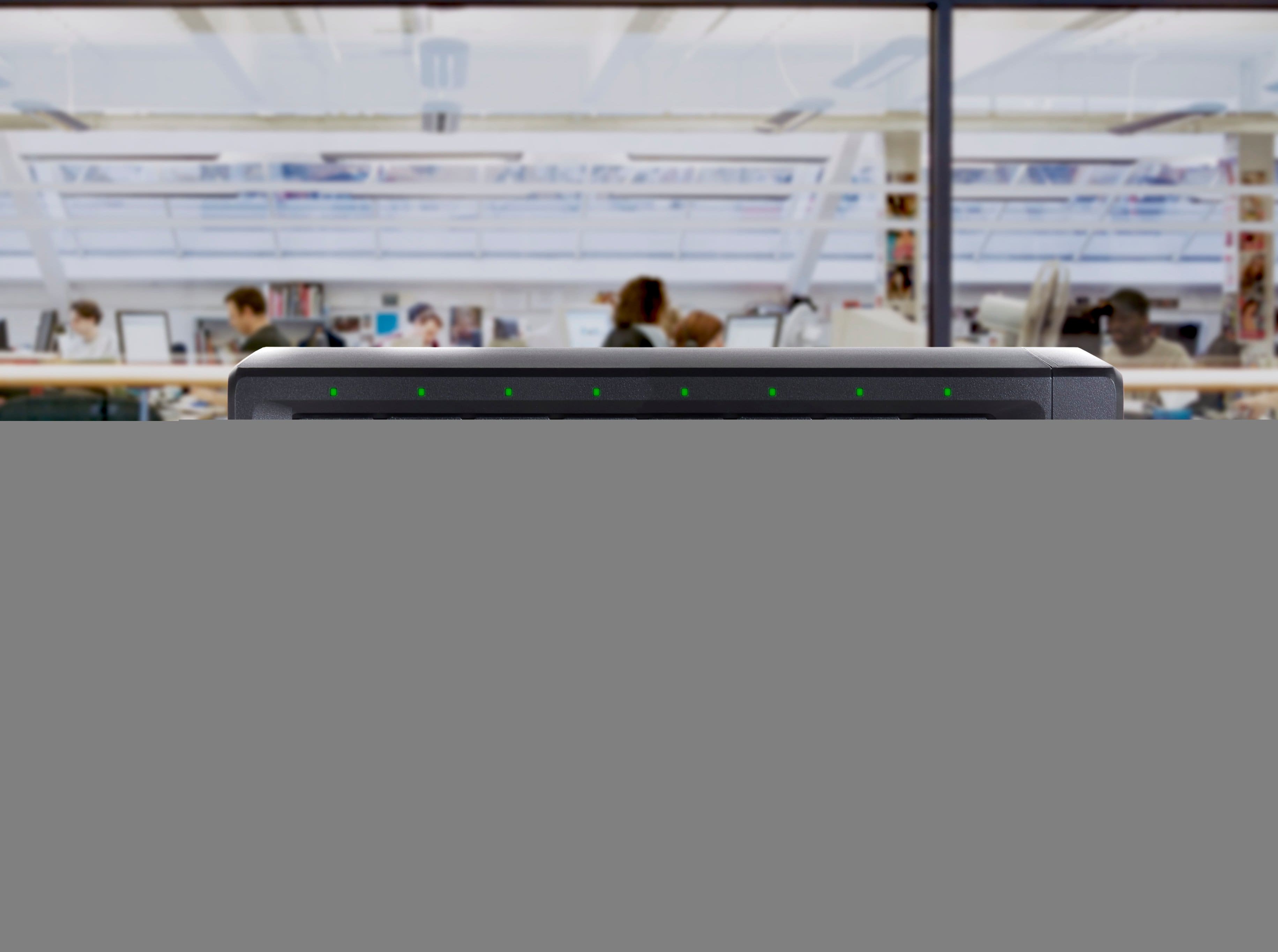 The image features a table with a WD Red Pro 3.5" NAS HDD and a WD Red Plus 3.5" NAS HDD. The table is surrounded by people, and there are also two books placed on the table. The scene suggests that the people might be working or studying in a library or a similar environment.