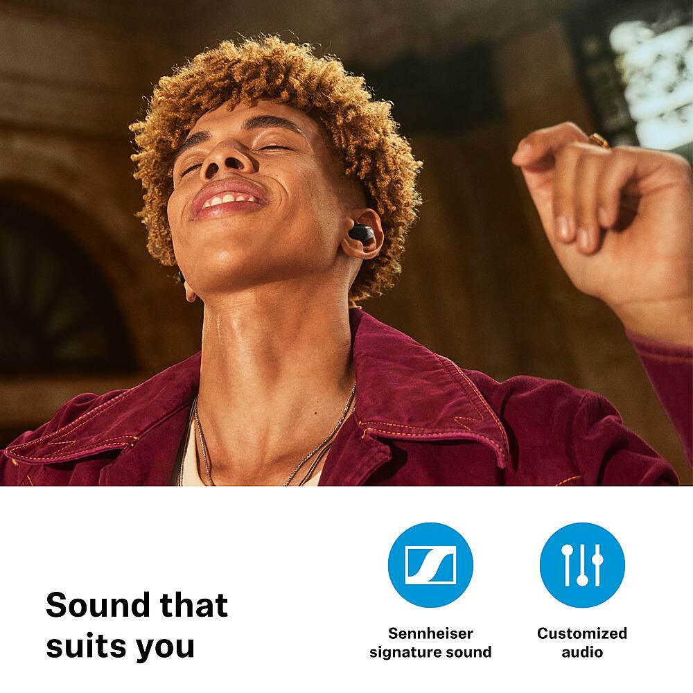 The image features a man with curly hair wearing a red jacket and a necklace, smiling and looking up. The man appears to be singing, and there is a microphone in the scene. The image is accompanied by text that reads "Sound that suits you Sennheiser signature sound Customized audio." This suggests that the man is using a Sennheiser microphone, which is known for its high-quality audio products. The text also implies that the sound is tailored to the user's preferences, providing a personalized audio experience.