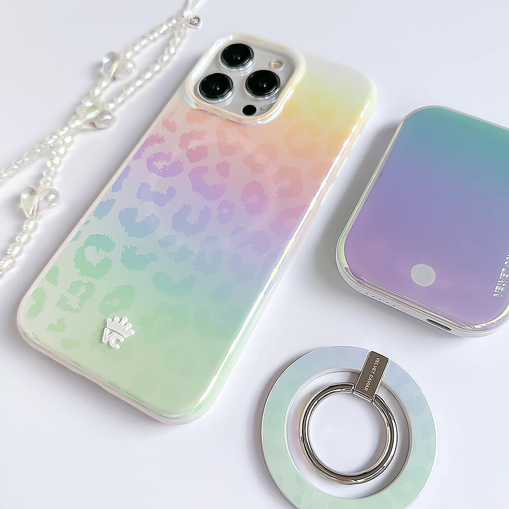 The image features a white cell phone case with a leopard print design and a heart on it. The case is placed on a white background, and there are other items nearby, such as a ring and a coin purse. The case is likely made of plastic and has a unique, eye-catching design.