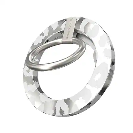 The image features a silver ring with a camouflage pattern on it. The ring is made by Velvet Caviar, a company known for its unique and stylish jewelry designs. The ring is displayed in a close-up view, showcasing its intricate details and the camouflage pattern that makes it stand out.