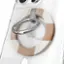 The image features a close-up view of a cell phone with a case on it. The case has a circular design and is made of metal. The case is attached to the cell phone with a ring, which is also made of metal. The ring is located near the top of the cell phone. The case and ring are both made of metal and have a silver color. The case is designed to protect the cell phone and add a touch of style to it.