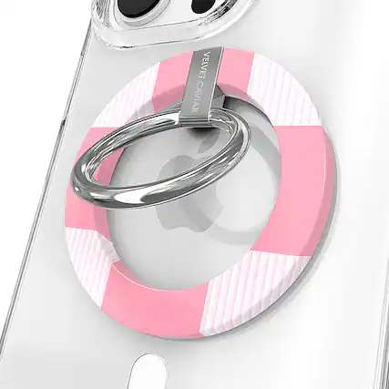 The image features a white cell phone with a pink and white case on it. The case has a ring attached to it, which is likely used for attaching the phone to a wrist or other objects. The case is designed by Velvet Caviar, and it adds a touch of style and personalization to the phone.