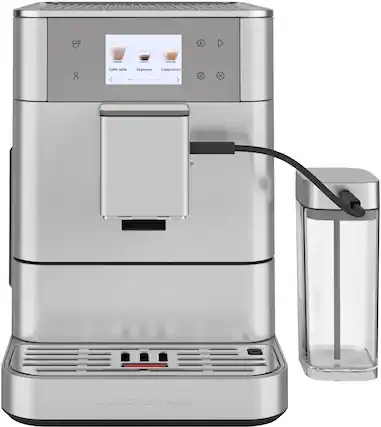The image features a silver KitchenAid coffee maker with a glass carafe and a cup. The coffee maker is turned on and ready to brew a cup of coffee. The coffee maker is placed on a countertop, and the glass carafe is located next to it. The cup is also placed nearby, ready for use.