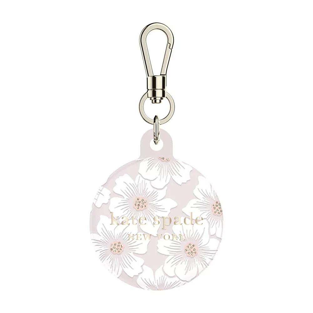 The image features a Kate Spade item tracker case with a floral design. The case is round and has a silver chain attached to it. The case is designed to attach to a bag or other personal belongings, making it easy to locate and keep track of items. The Kate Spade brand is known for its stylish and functional accessories, and this item tracker case is no exception.