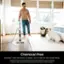 The image features a man standing in a living room, holding a steam mop and smiling. There are two dogs in the room, one on the left side and the other on the right side of the man. The scene suggests that the man is using the steam mop to clean the floor, possibly as a chemical-free sanitizing option for the whole family. The advertisement emphasizes the power of steam and its safety for the entire family, while also providing instructions and details on sanitization in the Owner's Guide.