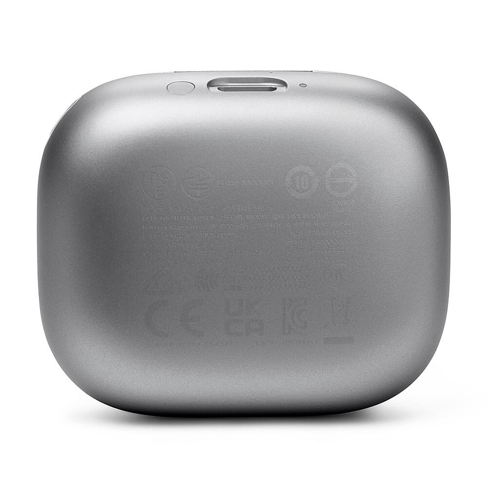 The image features a small, silver box with a white background. The box is labeled with a variety of logos and text, including "Rohs," "Ukca," "CE," and "FCC." The logos and text are arranged in a way that covers the majority of the box's surface. The box appears to be a small electronic device, possibly a speaker or a charger, given the presence of these logos and the fact that it is a square shape.