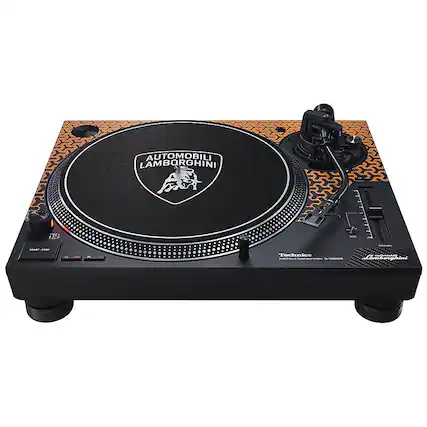 The image features a black and orange turntable with the brand name "Automobili Lamborghini" on it. The turntable is placed on a black stand and is accompanied by a pair of speakers. The design of the turntable is unique, as it is shaped like a car, making it a distinctive piece of audio equipment.