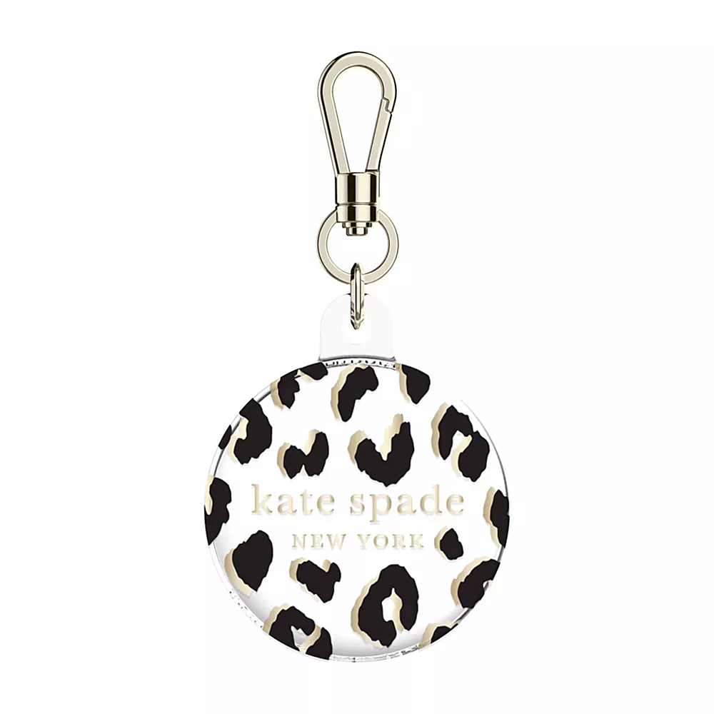 The image features a Kate Spade New York keychain with a leopard print design. The keychain is round and has a gold clasp. The Kate Spade logo is prominently displayed on the keychain, making it a stylish and functional accessory for the user.